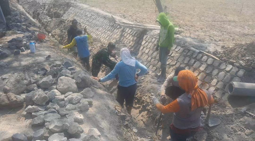 You are currently viewing Babinsa Kodim Madiun Bantu Warga Bangun Saluran Irigasi