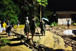 Read more about the article Luapan Sungai Tutup Jalan Nasional Prigi, Aparat dan Warga Bergotong Royong Bersihkan Lumpur