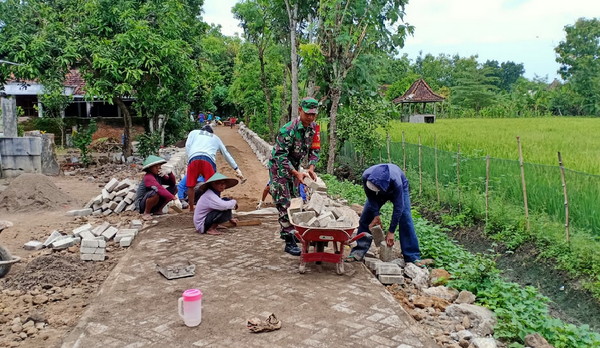 Read more about the article Babinsa Koramil Pilangkenceng Bantu Warga Pasang Paving Jalan Desa
