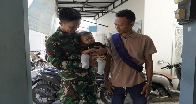 Read more about the article Sentuhan Hangat TMMD 129 Bojonegoro: Ketika Seragam Loreng Menjaga Senyum Sang Balita di Kesongo