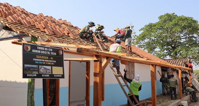 You are currently viewing Menembus Terik, Menjaga Harapan: Satgas TMMD 129 Bojonegoro dan Warga Bahu-Membahu Pasang Genteng Rumah Bu Tini