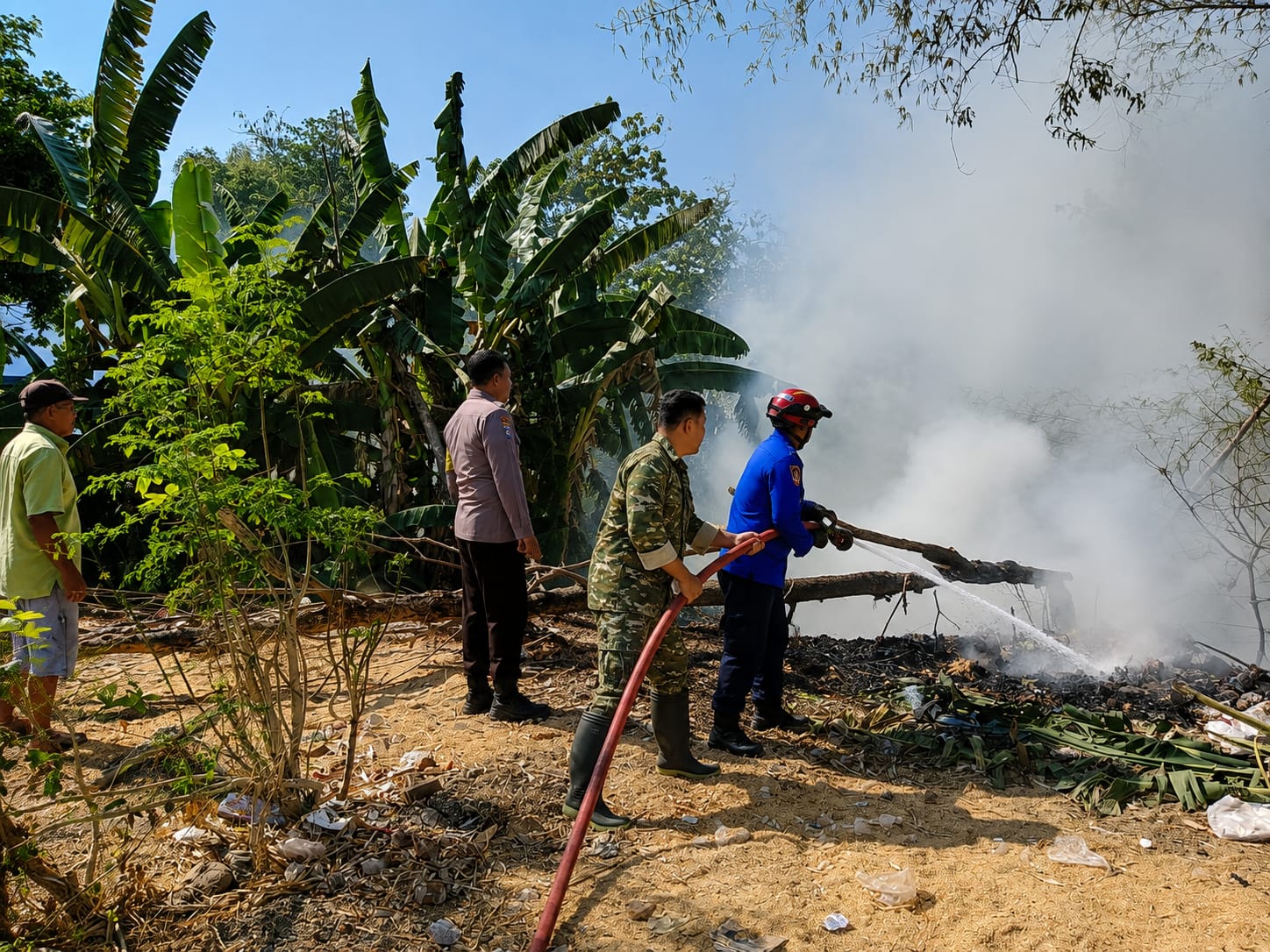 Read more about the article Api Lahap Tumpukan Sampah dan Rumpun Bambu, Babinsa Bersama Damkar Berjibaku Jinakkan Api