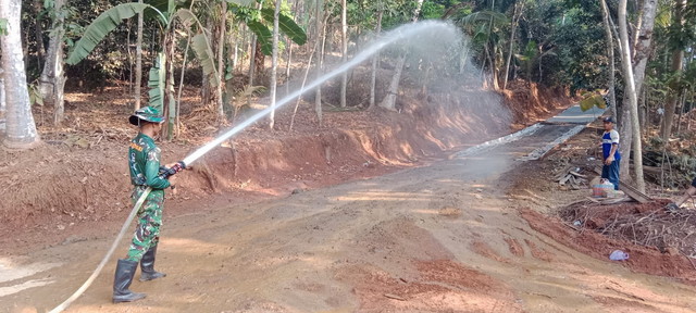 Read more about the article Satgas TMMD Siram Permukaan Jalan Sebelum Pengecoran, Pastikan Pekerjaan Berjalan Secara Optimal