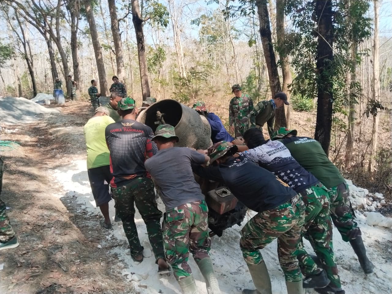 You are currently viewing Tujuh Personel Satgas TMMD Dorong Mesin Molen ke Lokasi Pengerjaan Berikutnya