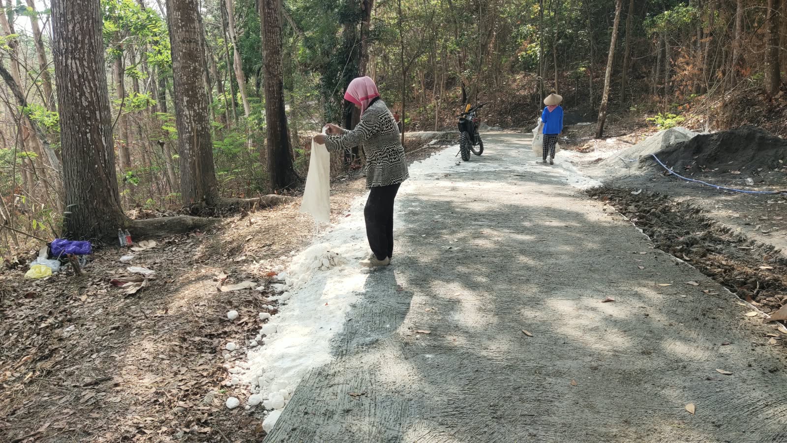 You are currently viewing Ibu Suhartini Ikut Membantu Penimbunan Pedel di Batas Beton Jalan TMMD Ngajaran
